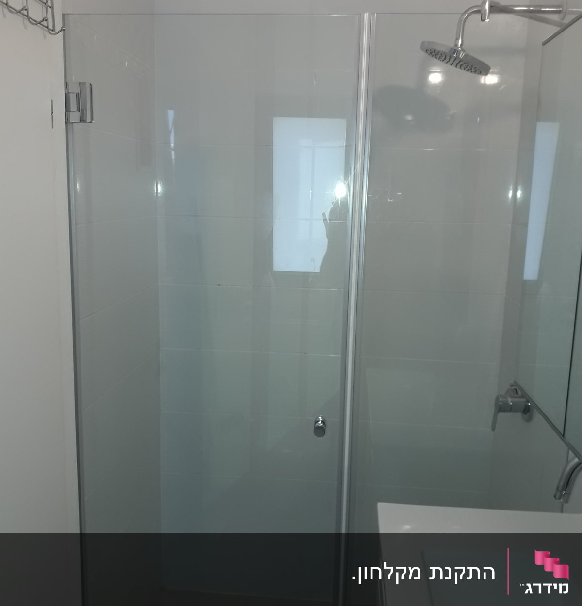 מקלחת עם דלת זכוכית וראש מקלחת עגול